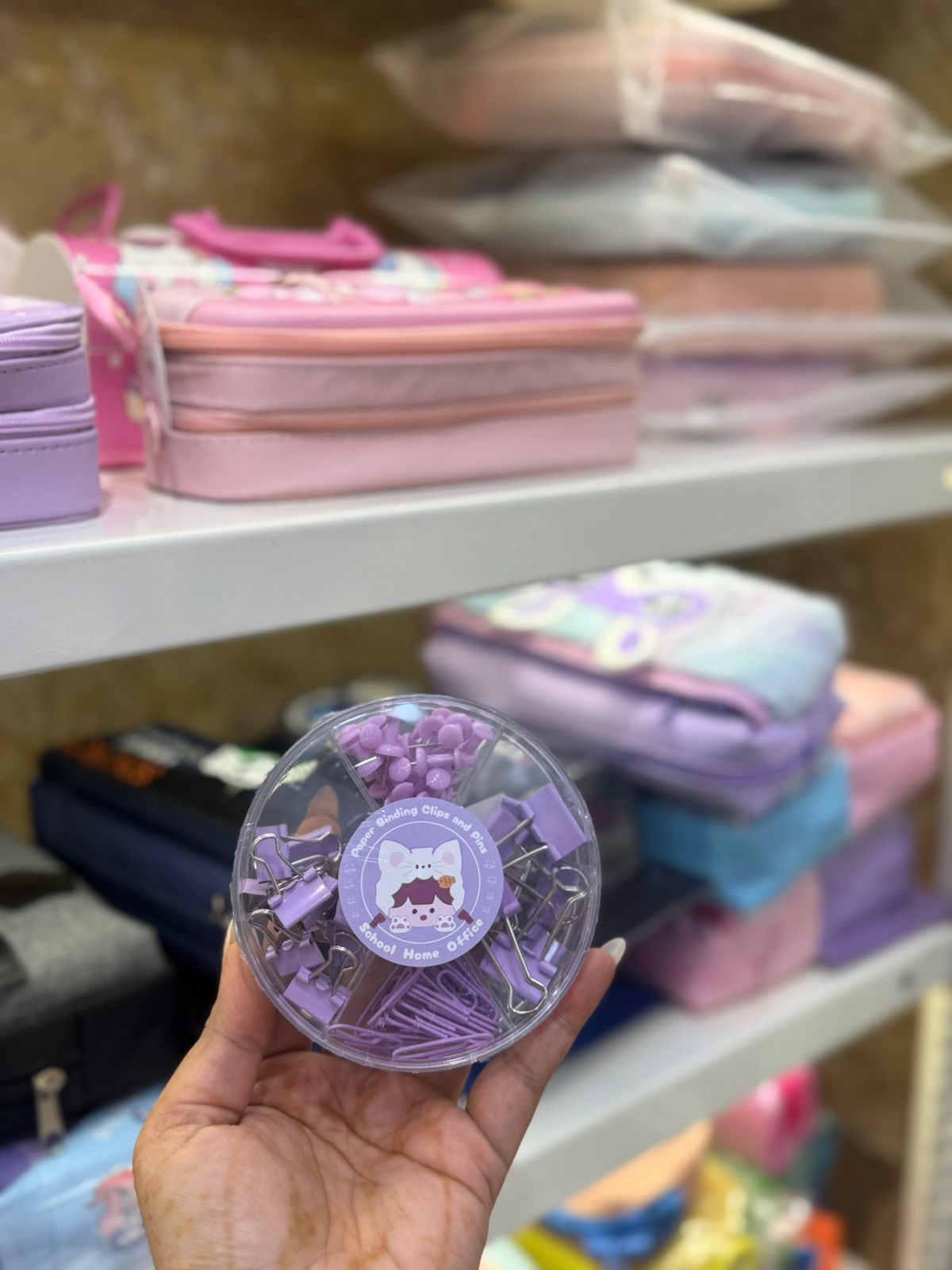 Round box with purple binder clips and pins